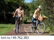 young couple enjoying in a bike ride through the park. Стоковое фото, агентство Ingram Publishing / Фотобанк Лори