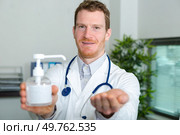 doctor holding pump dispenser of antibacterial handwash. Стоковое фото, агентство Ingram Publishing / Фотобанк Лори