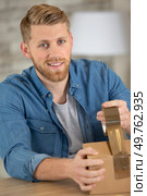 happy man using an adhesive tape on a cardbox. Стоковое фото, агентство Ingram Publishing / Фотобанк Лори