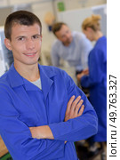 portrait of apprentice engineer posing crossing arms in laboratory. Стоковое фото, агентство Ingram Publishing / Фотобанк Лори