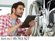 man is repairing a wheelchair at workshop. Стоковое фото, агентство Ingram Publishing / Фотобанк Лори