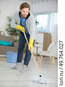 young man cleaning mopping the floor. Стоковое фото, агентство Ingram Publishing / Фотобанк Лори