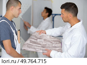 worker looking at linoleum flooring. Стоковое фото, агентство Ingram Publishing / Фотобанк Лори