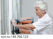 Builder using a nail gun. Стоковое фото, агентство Ingram Publishing / Фотобанк Лори