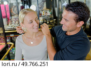 woman trying a necklace with husband at a jewellery shop. Стоковое фото, агентство Ingram Publishing / Фотобанк Лори