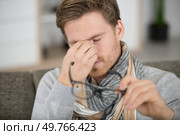 young man rubbing eye on white background annoying itch. Стоковое фото, агентство Ingram Publishing / Фотобанк Лори