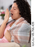 young girl sitting on the sofa and yawning. Стоковое фото, агентство Ingram Publishing / Фотобанк Лори