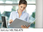 office woman in white shirt holding document folder. Стоковое фото, агентство Ingram Publishing / Фотобанк Лори
