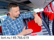 Man securing protector to bus headrest. Стоковое фото, агентство Ingram Publishing / Фотобанк Лори