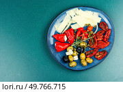 Greek appetizer of sun-dried tomatoes, black and green olives and stuffed cheese with marinated red peppers. Copy space.. Tasty antipasto mix. Стоковое фото, агентство Ingram Publishing / Фотобанк Лори