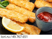 Crumbed fried fish fingers in sticks with sauce. Seafood. Close up.. Crispy fish strips with sauce. Стоковое фото, агентство Ingram Publishing / Фотобанк Лори