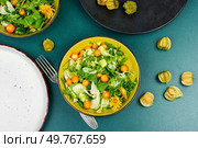 Tasty dishes from wild plants. Vitamin salad. Healthy food concept. Low calories vegetarian food.. Fresh salad from wild plants and physalis. Стоковое фото, агентство Ingram Publishing / Фотобанк Лори