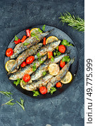 Portion of fried sardines served on plate on a concrete kitchen table. Top view.. Roasted fish on table. Стоковое фото, агентство Ingram Publishing / Фотобанк Лори