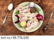 Raw chicken legs, food ingredients on wooden rustic background. Chicken drumsticks or legs.. Raw chicken drumsticks. Стоковое фото, агентство Ingram Publishing / Фотобанк Лори