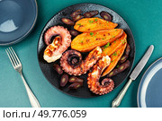 Delicious grilled octopus served with aromatic sweet potato or yam. Fried octopus. Top view.. Summer barbecue with octopus. Стоковое фото, агентство Ingram Publishing / Фотобанк Лори
