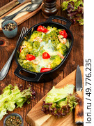 Roasted green broccoli with shrimp, baked vegetables, casserole on rustic wooden table.. Oven baked broccoli topped with melted mozzarella and prawns. Стоковое фото, агентство Ingram Publishing / Фотобанк Лори