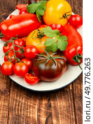 Assorted heirloom tomatoes on a rustic wooden table. Ripe tomatoes on rustic wooden background. Стоковое фото, агентство Ingram Publishing / Фотобанк Лори