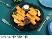 Crumbed fried fish fingers in sticks with sauce. Fast food.. Breaded fish fingers with lemon. Стоковое фото, агентство Ingram Publishing / Фотобанк Лори