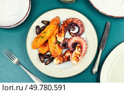 Appetizing grilled octopus and baked sweet potato wedges on a plate.. Delicious grilled octopus and sweet potato. Стоковое фото, агентство Ingram Publishing / Фотобанк Лори