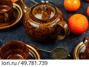 Modern style tea pot with tangerines tea and ripe fruits.. Tangerine tea in a glass teakettle. Стоковое фото, агентство Ingram Publishing / Фотобанк Лори