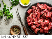 Raw diced beef meat for stew on rustical table with ingredients, top. Стоковое фото, агентство Ingram Publishing / Фотобанк Лори