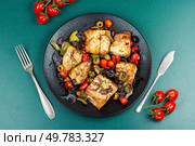 Delicious baked mackerel fillet with paprika, tomatoes, and olives on a plate. Flat lay. Oven baked mackerel. Стоковое фото, агентство Ingram Publishing / Фотобанк Лори