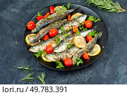 A plate of baked grilled sardines garnished with lemon,cherry tomatoes and rosemary. Greece cuisine.. Grilled sardines on a plate with lemon. Стоковое фото, агентство Ingram Publishing / Фотобанк Лори