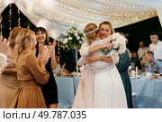 bride in a white dress throws a wedding bouquet to her unmarried girlfriends. Стоковое фото, агентство Ingram Publishing / Фотобанк Лори