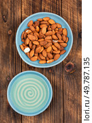 Dried almonds and aromatic almond oil on rustic wooden table. Almond kernels. Tasty organic almond nuts.. Heap of almond nuts and almond oil. Стоковое фото, агентство Ingram Publishing / Фотобанк Лори