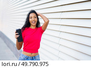 In a bright and lively environment, a cheerful young woman poses playfully with her phone, beautifully encapsulating the essence of youth, joy, and an exciting, vibrant spirit of the moment. A Joyful Young Woman Posing Happily with Her Phone Against a Vibrant Modern Background. Стоковое фото, агентство Ingram Publishing / Фотобанк Лори