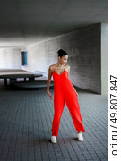 In a stunning contemporary architectural space, a fashionforward model confidently showcases a vibrant and eyecatching red jumpsuit, perfectly highlighting both elegance and modern style. A Stylish Model Dressed in a Bright Red Jumpsuit Posing Gracefully in a Modern Architectural Space. Стоковое фото, агентство Ingram Publishing / Фотобанк Лори