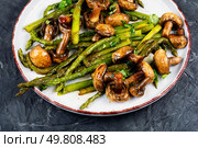 Organic green asparagus fried with mushrooms and greens.. Roasted juicy asparagus with champignons. Стоковое фото, агентство Ingram Publishing / Фотобанк Лори