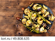 Grilled fish and veggie skewers, BBQ on rustic wooden table. Space for text.. Delicious food on skewers, fish kebabs. Стоковое фото, агентство Ingram Publishing / Фотобанк Лори