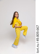 Cheerful funny genius positive little girl with curly hair in summer yellow suit has fun, jumping, dancing on white background. Happy childhood concept. Copy space. High quality photo. Стоковое фото, фотограф Ирина Михайличенко / Фотобанк Лори