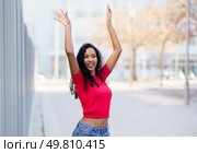 A vibrant, energetic young woman wearing a stylish pink top joyfully and confidently poses outdoors, capturing the essence of positivity, selfexpression, and freedom in a lively modern urban setting. A Joyful Young Woman Posing Outdoors with Unwavering Confidence and Radiant Spirit. Стоковое фото, агентство Ingram Publishing / Фотобанк Лори
