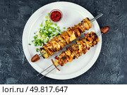 Roasted or grilled bacon, meat skewers with roasted potatoes and sauce. Flat lay. Summer cookout, meat and vegetables roast on skewers. Стоковое фото, агентство Ingram Publishing / Фотобанк Лори