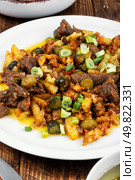 A traditional dish of Tatar cuisine, consisting of fried pieces of beef stewed with onions, potatoes and pickles.. Azu is a traditional dish of Tatar cuisine on wooden surface. Стоковое фото, агентство Ingram Publishing / Фотобанк Лори