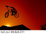 Bmx rider at jump against sky at sunset. Стоковое фото, агентство Ingram Publishing / Фотобанк Лори