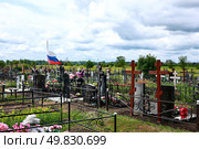 Кладбище с новыми могилами и крестами развивается флаг России: воинская слава героям, защитникам, воинам / The cemetery with new graves and crosses displays the flag of Russia: military glory to heroes, defenders, soldiers. Стоковое фото, фотограф Roman Savateev / Фотобанк Лори