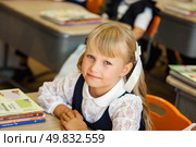 First-grader Brightens Classroom With Her Charming Smile and Eager Spirit. Стоковое фото, фотограф Aleksandr Golubev / Фотобанк Лори