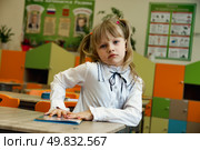 Imaginative First-Grader Pondering in a Vibrant Classroom Setting Filled With Colors and Creativity. Стоковое фото, фотограф Aleksandr Golubev / Фотобанк Лори