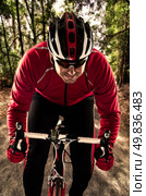 Cyclist on road bike through a forest. Стоковое фото, агентство Ingram Publishing / Фотобанк Лори