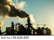 Smoking chimney  at sunset on industrial buildings complex. Стоковое фото, агентство Ingram Publishing / Фотобанк Лори