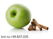 Ripe green apple with cinnamon sticks over reflective white background. Стоковое фото, агентство Ingram Publishing / Фотобанк Лори
