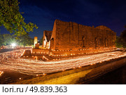 candle light trail of Buddhism Ceremony at temple ruin on Asalha Puja day. Стоковое фото, агентство Ingram Publishing / Фотобанк Лори