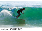 Long boarder surfing the waves at sunset in Portugal. Стоковое фото, агентство Ingram Publishing / Фотобанк Лори