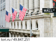 Wall street sign in New York with New York Stock Exchange background. Стоковое фото, агентство Ingram Publishing / Фотобанк Лори