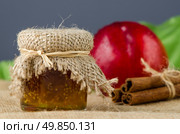 Peach jam with fruit and cinnamon over raffia background. Стоковое фото, агентство Ingram Publishing / Фотобанк Лори