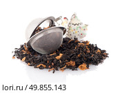 Aromatic black dry tea with petals and a tea strainer on white reflective background. Стоковое фото, агентство Ingram Publishing / Фотобанк Лори