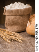 Rustic bread and wheat on an old vintage planked wood table. Стоковое фото, агентство Ingram Publishing / Фотобанк Лори